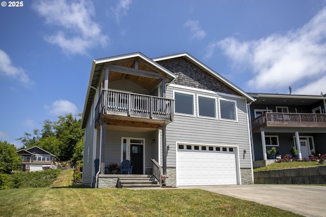 2343 N Fork Rd, Seaside, OR 97138 - view of front of house with a balcony, a garage, concrete driveway, a front yard, and stone siding