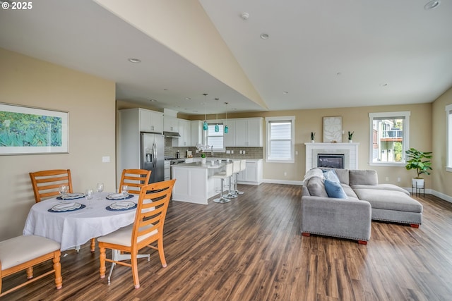 2343 N Fork Rd, Seaside, OR 97138 - dining room with dark wood finished floors, lofted ceiling, a glass covered fireplace, recessed lighting, and baseboards