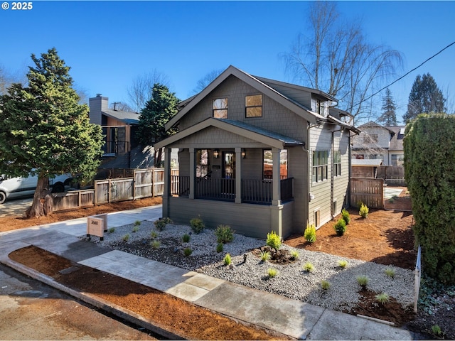 bungalow featuring covered porch and fence