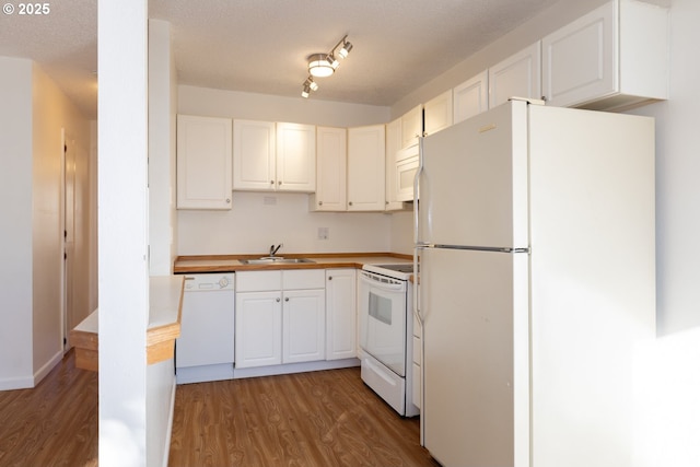 kitchen with white cabinets, hardwood / wood-style floors, white appliances, and sink