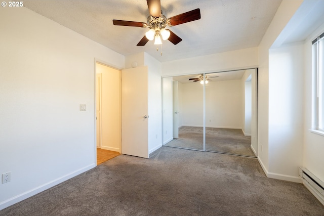 unfurnished bedroom with carpet flooring, ceiling fan, a closet, and a baseboard heating unit