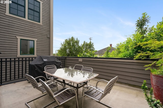 view of patio featuring outdoor dining area, grilling area, and fence