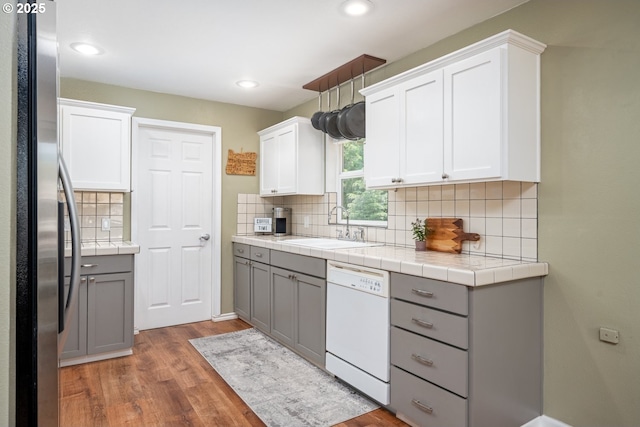 33218 SW Day St, Scappoose, OR 97056 - kitchen with white dishwasher, freestanding refrigerator, gray cabinets, wood finished floors, and backsplash