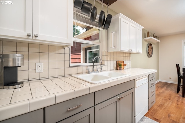 33218 SW Day St, Scappoose, OR 97056 - kitchen with white dishwasher, light wood-style flooring, white cabinets, and tasteful backsplash