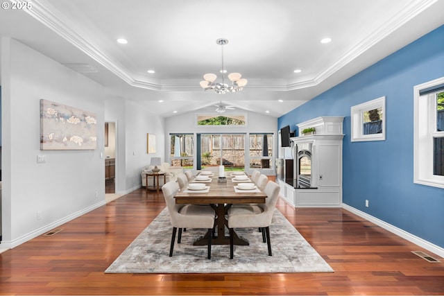 dining room featuring an inviting chandelier, a healthy amount of sunlight, dark hardwood / wood-style floors, and a tray ceiling