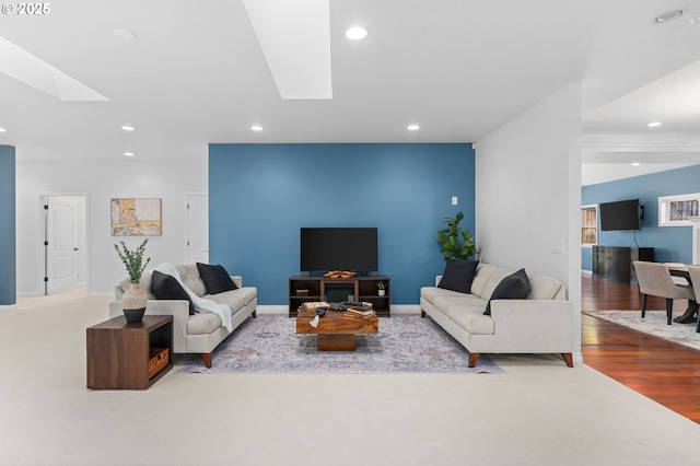 living room with light hardwood / wood-style floors and a skylight