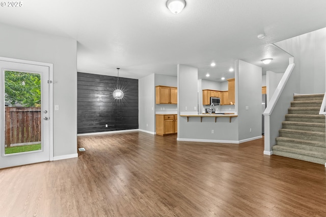 21125 SW Ladyfern Dr, Sherwood, OR 97140 - unfurnished living room with an accent wall, baseboards, dark wood-type flooring, stairs, and recessed lighting
