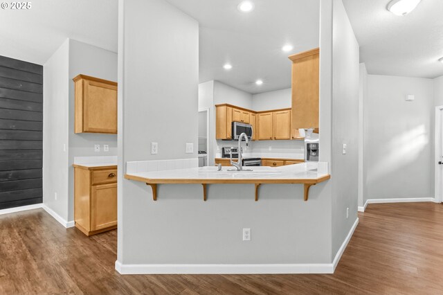 21125 SW Ladyfern Dr, Sherwood, OR 97140 - kitchen featuring stainless steel appliances, dark wood-style flooring, baseboards, a breakfast bar area, and recessed lighting