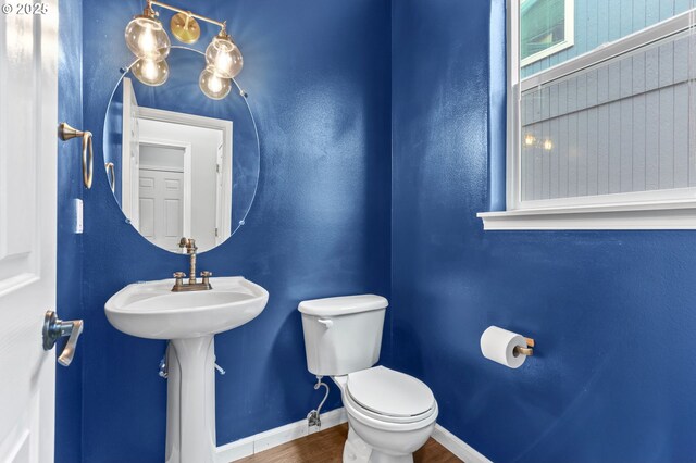 21125 SW Ladyfern Dr, Sherwood, OR 97140 - half bathroom with wood finished floors, toilet, and baseboards