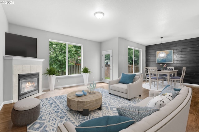 21125 SW Ladyfern Dr, Sherwood, OR 97140 - living area featuring wood finished floors, a tiled fireplace, wooden walls, and baseboards