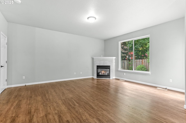 21125 SW Ladyfern Dr, Sherwood, OR 97140 - unfurnished living room with wood finished floors, a tile fireplace, and baseboards