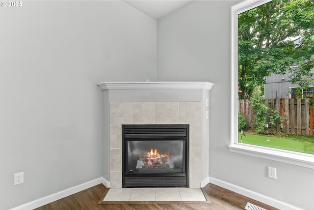 21125 SW Ladyfern Dr, Sherwood, OR 97140 - detailed view of baseboards, a tile fireplace, and wood finished floors