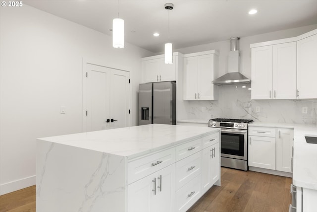 8120 SE 145th Ct, Portland, OR 97236 - kitchen with appliances with stainless steel finishes, wall chimney exhaust hood, recessed lighting, a kitchen island, and wood finished floors