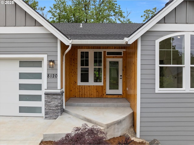 8120 SE 145th Ct, Portland, OR 97236 - doorway to property with an attached garage, a shingled roof, stone siding, and board and batten siding