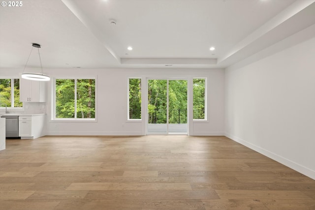 8120 SE 145th Ct, Portland, OR 97236 - unfurnished living room featuring baseboards, light wood-type flooring, recessed lighting, and a raised ceiling