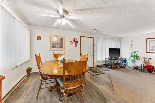 dining area with baseboard heating, ceiling fan, carpet floors, and a textured ceiling