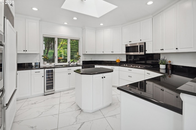1308 Northshore Rd, Lake Oswego, OR 97034 - kitchen featuring wine cooler, appliances with stainless steel finishes, recessed lighting, light marble finish floors, and a skylight