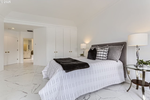 bedroom featuring marble finish floors and a closet