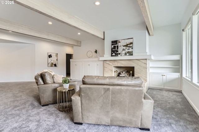 living area featuring carpet flooring, beam ceiling, recessed lighting, a high end fireplace, and baseboards