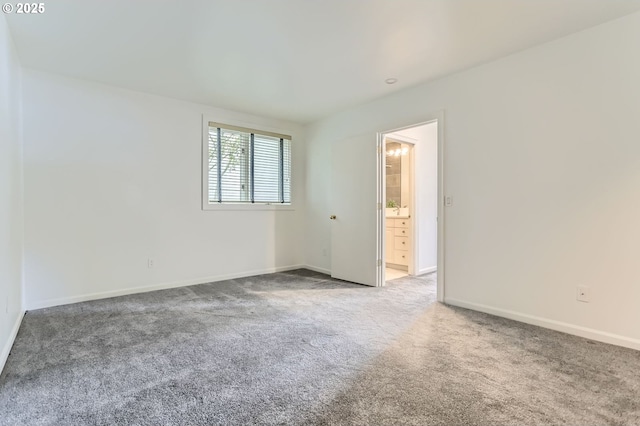 carpeted empty room featuring baseboards