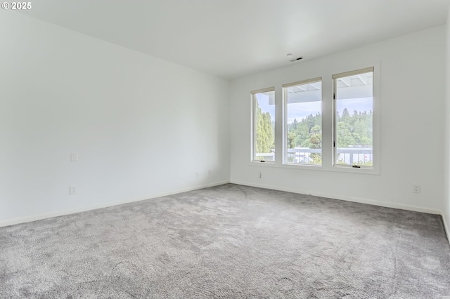 spare room featuring carpet floors and baseboards