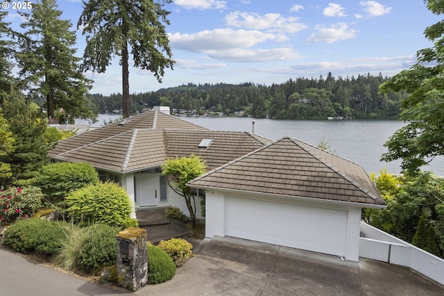 1308 Northshore Rd, Lake Oswego, OR 97034 - view of front of house featuring a wooded view, driveway, a tiled roof, and a water view