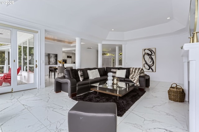living room with a raised ceiling and marble finish floors