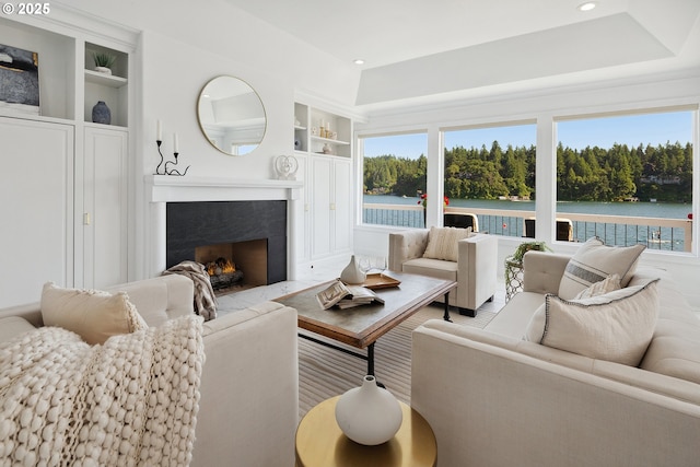 1308 Northshore Rd, Lake Oswego, OR 97034 - living area with healthy amount of natural light, a fireplace, built in shelves, recessed lighting, and a water view