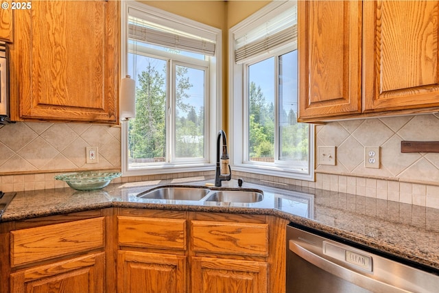 308 SW 38th Loop, Gresham, OR 97080 - kitchen with stainless steel dishwasher, decorative backsplash, brown cabinets, and stone countertops