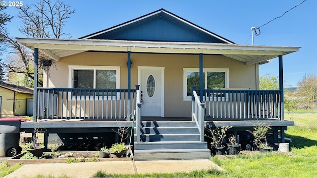 bungalow with stucco siding, stairs, and covered porch