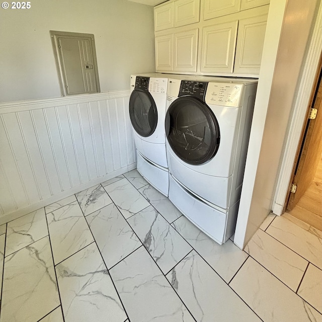 laundry room with marble finish floor, a wainscoted wall, electric panel, separate washer and dryer, and cabinet space