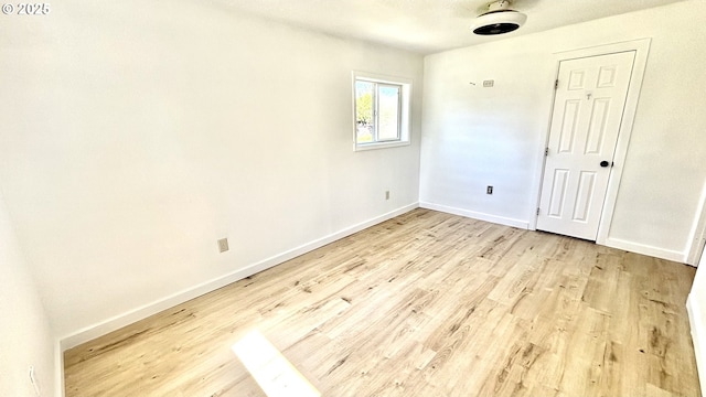 spare room featuring baseboards and wood finished floors