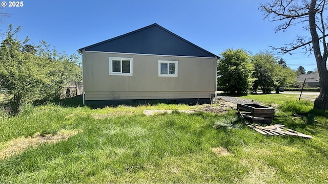view of side of home with crawl space and a yard