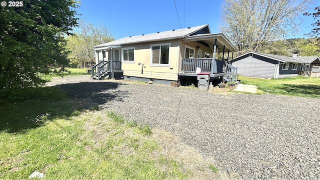 view of front of property with a porch, crawl space, roof with shingles, and a front yard