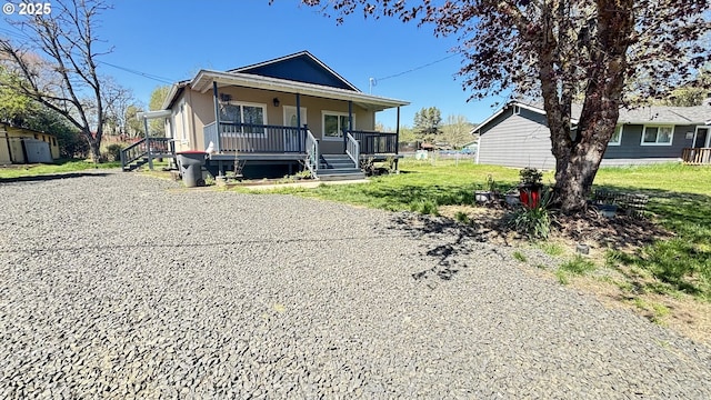 view of front facade featuring a front lawn, a porch, an outbuilding, and a shed