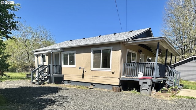 view of side of property featuring roof with shingles, a porch, and crawl space