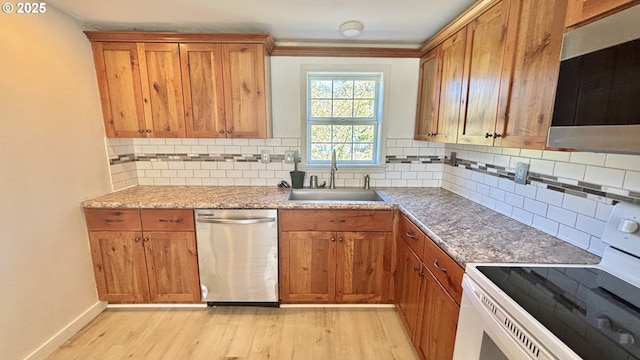 kitchen featuring a sink, brown cabinetry, decorative backsplash, stainless steel appliances, and light wood finished floors