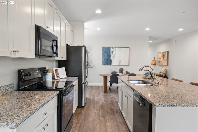 2310 S Heather St, Cornelius, OR 97113 - kitchen featuring black appliances, wood finished floors, recessed lighting, white cabinets, and a center island with sink