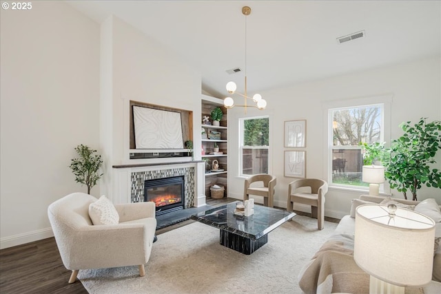 living area featuring a healthy amount of sunlight, visible vents, a fireplace, and baseboards