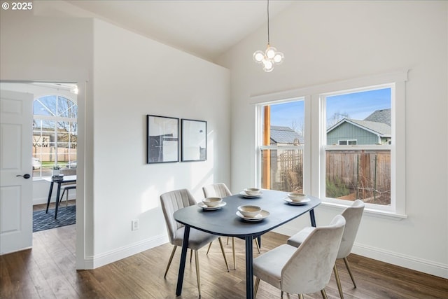 dining space featuring plenty of natural light, vaulted ceiling, and wood finished floors