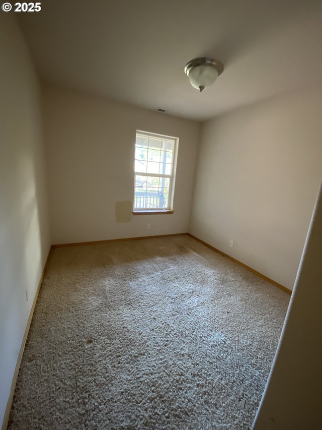 carpeted spare room featuring baseboards