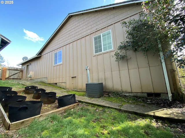 view of side of property with board and batten siding and fence