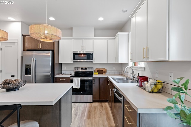 88104 7th St, Veneta, OR 97487 - kitchen with appliances with stainless steel finishes, a sink, light countertops, light wood-style floors, and white cabinets