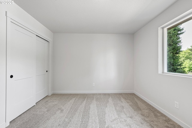 88104 7th St, Veneta, OR 97487 - unfurnished bedroom with light carpet, multiple windows, baseboards, and a closet