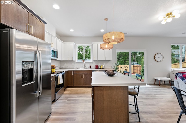 88104 7th St, Veneta, OR 97487 - kitchen featuring appliances with stainless steel finishes, plenty of natural light, light countertops, a breakfast bar area, and recessed lighting
