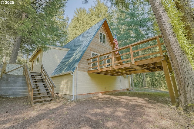 48395 High Leah Dr, Oakridge, OR 97463 - back of property with stairs, a wooden deck, a metal roof, dirt driveway, and a carport