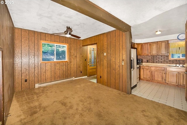 48395 High Leah Dr, Oakridge, OR 97463 - kitchen featuring baseboard heating, light countertops, ceiling fan, brown cabinetry, and wood walls
