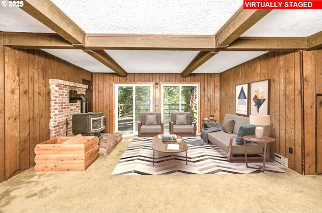 48395 High Leah Dr, Oakridge, OR 97463 - living room with a wood stove, a baseboard heating unit, beam ceiling, carpet flooring, and wood walls