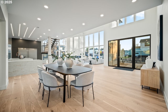 dining space featuring recessed lighting, a high ceiling, and light wood finished floors