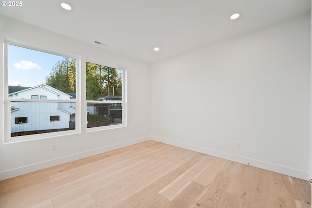 unfurnished room with visible vents, baseboards, wood finished floors, and recessed lighting